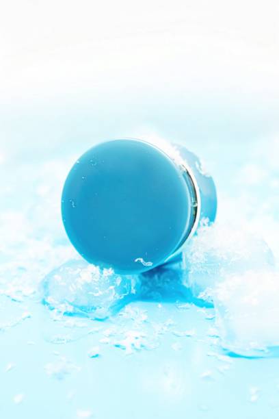 istock Blue round plastic container with cosmetic substances, on blue background with ice cubes and snow. Refreshing skin care concept. 2125637091
