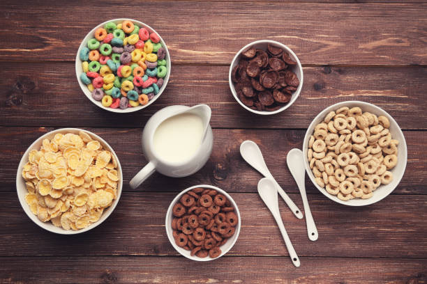 istock Various corn flakes with milk in jar and spoons on brown wooden table 2125647406