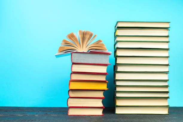 istock Open book, hardback books on wooden table, on a blue background. Back to school. Copy space for text. Education background. 2125652555