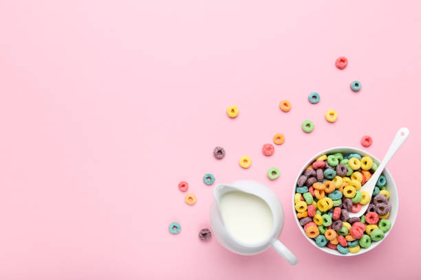 istock Colorful corn rings with milk in jar and spoon on pink background 2125667003