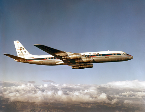 California, USA - between 1961 and 1967: Douglas DC-8-50 flying over the Sierra Nevada Mountains.