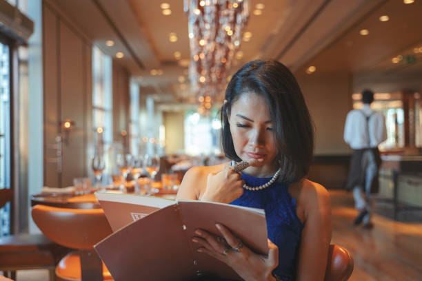 istock Young woman is looking menu in a restaurant 2125756531