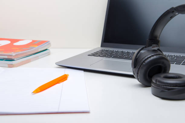 Laptop with headphones and note book on the desk