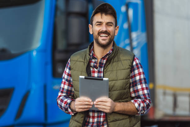 istock Happy confident male driver standing in front on his truck, using his tablet. 2125858706