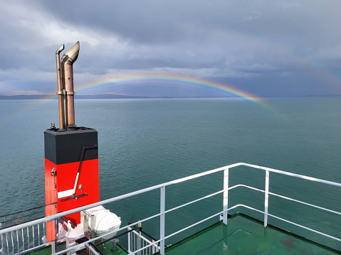 Rainbow over sea captured during ferry journey to Isle of Mull UK