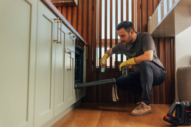 istock Man spraying cleaner on oven drawer 2125917278
