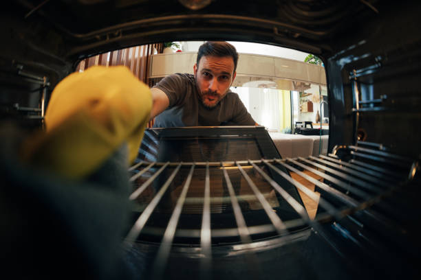 istock Man cleaning inside of oven with focus 2125921541