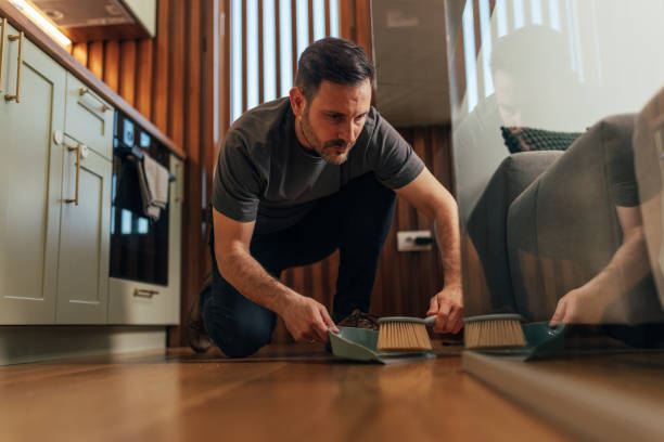istock Man cleaning floor with dustpan and brush 2125936018