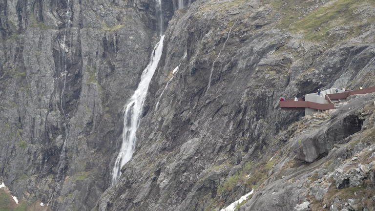 viewing platform at a waterfall in the mountain landscape at the Trollstigen scenic road in the mountains of Norway.