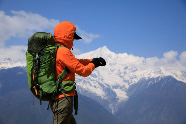 istock Woman backpacker set the smartwatch on high altitude mountains 2126142623