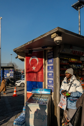 Istanbul, Turkey March 19, 2024 A young man stands at a news and snack kiosk in the downtown.