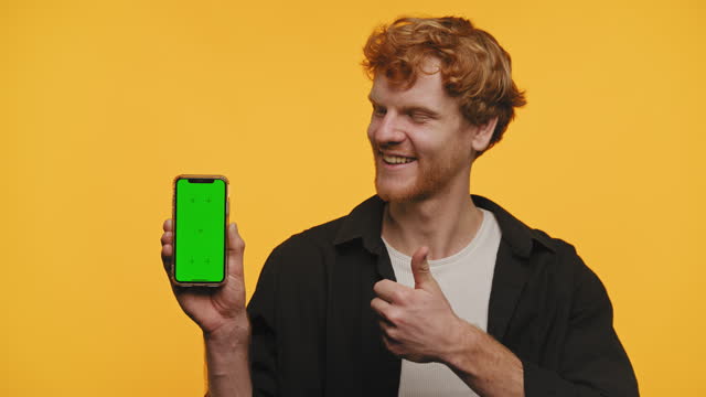 Cheerful Man Showing Smartphone with Green Screen