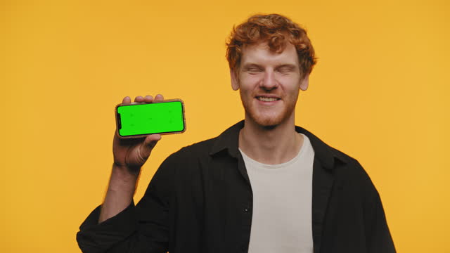 Red Haired Man Admiring Smartphone with Green Screen