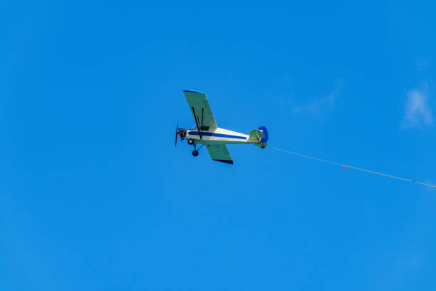 Aerial advertising banner airplane on a blue sky with visible rope