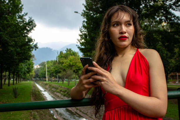 Young beautiful woman using cell phone in front of modern building