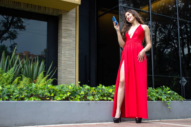 Young beautiful woman using cell phone in front of modern building