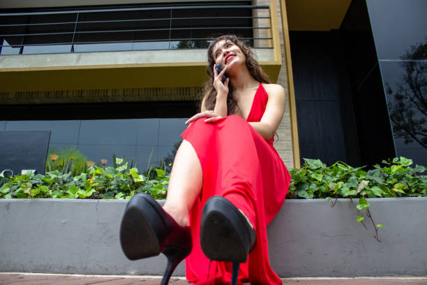 Young beautiful woman using cell phone in front of modern building