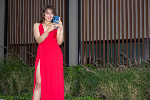 Young beautiful woman using cell phone in front of modern building