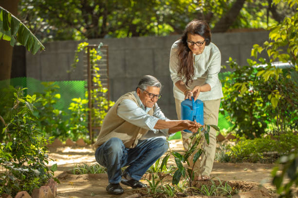 istock Happy retired elderly couple watering plants in backyard 2126449866