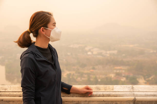 Asian woman wearing an N95 mask for protect bad air pollution. PM2.5 levels meaning the air quality posed a health hazard. protective-face-mask stock pictures, royalty-free photos & images