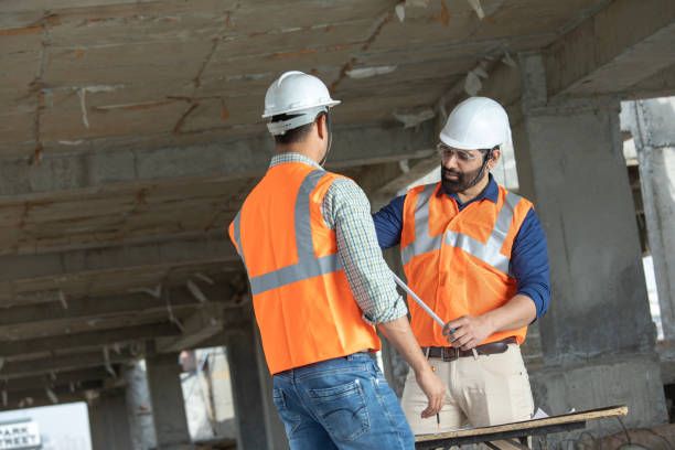 istock Male architects discussing construction details at site 2126482705
