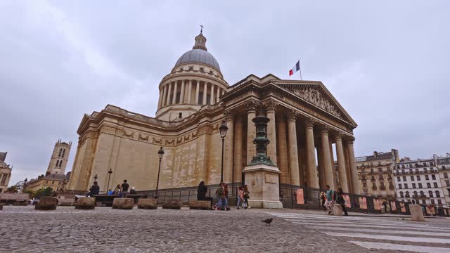 Majestic Panthéon dome under overcast skies in paris, france, with visitors gathering around