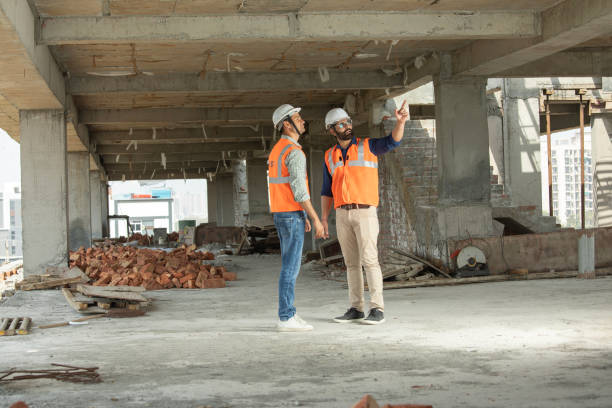 istock Male architects discussing construction details at site 2126504378