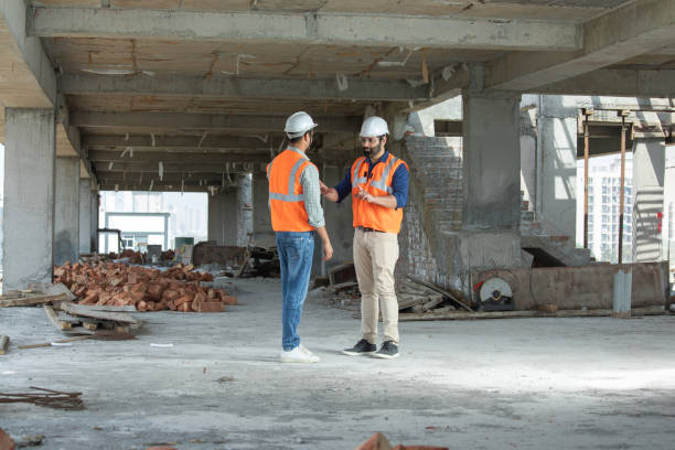 Male architects discussing construction details at site