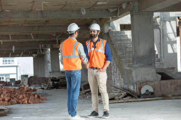 istock Male coworkers shaking hands at construction site 2126505417