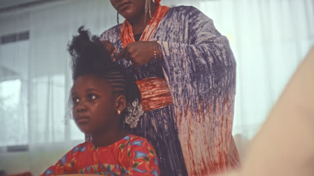 Mother Braiding Her Daughter’s Hair At Home