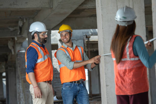 istock Construction coworkers measuring wall with tape at site 2126576920