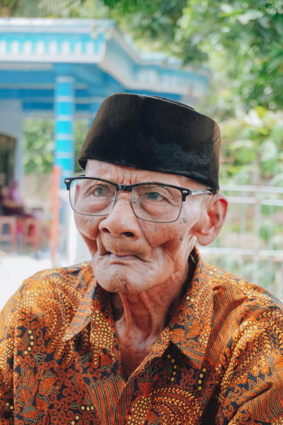 portret starego azjaty w batikowej koszuli i okularach - one person lifestyles 80 plus years indoors zdjęcia i obrazy z banku zdjęć