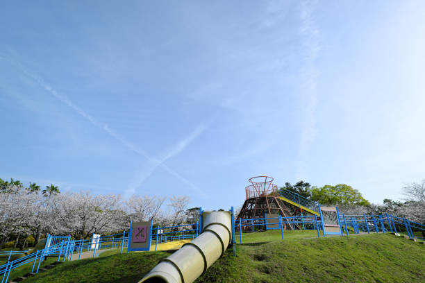 Children’s play equipment with red slides in front of an apartment building in Sapporo, Japan