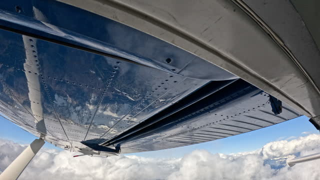 Wing suit flier leaves plane to soar above mountain landscape