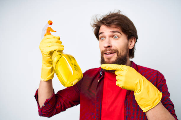 Man in rubber gloves detergent emotions red shirt housework. High quality photo