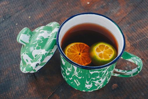 A photo of lemon tea served traditionally in blirik cup, isolated wooden background