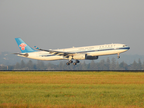 A China Southern Airlines Airbus A330-343 plane, registration B-1063, coming into land from the south on the main runway of Sydney Kingsford-Smith Airport as flight CZ3071 from Shenzhen. This image was taken from Mill Stream Lookout, Botany Bay on a sunny morning shortly after sunrise on 30 March 2024.