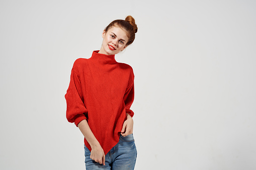 woman in fashionable glasses and in a red sweater gestures with her hands. High quality photo