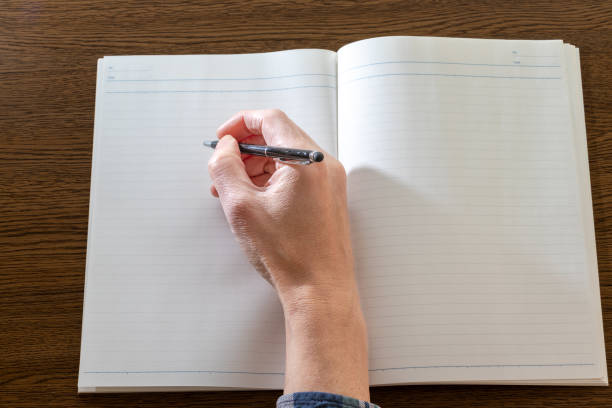 istock Write something with a pen in a notebook open on the desk 2126725042