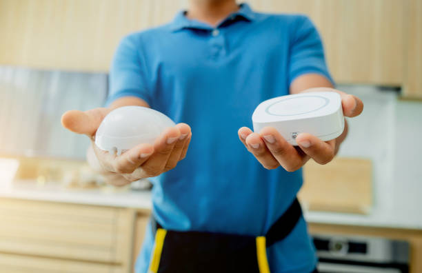 a technician installs a security alarm siren and motion sensor detector. - sensory perception flash zdjęcia i obrazy z banku zdjęć