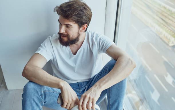 istock A man sits on a windowsill with a phone rest internet communication 2126745526