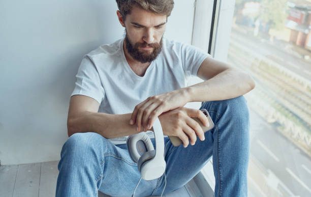 istock A man sits on a windowsill with a phone rest internet communication 2126752420