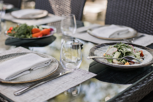 a Fresh garden salad on an elegantly set outdoor dining table, perfect for al fresco dining experiences
