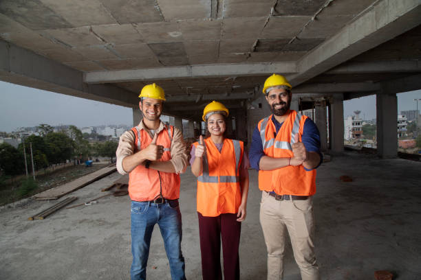 istock Low angle view of confident architects in protective workwear showing thumbs up inside building at site 2126799453