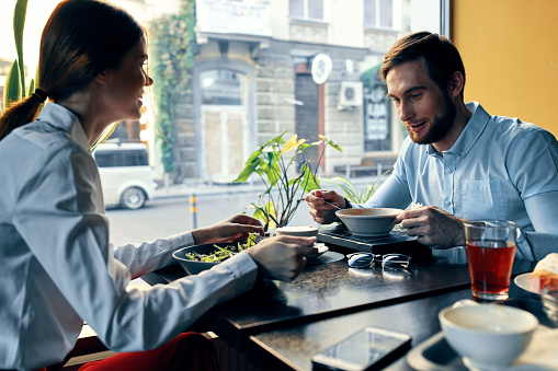 woman and business man have dinner at a table in a cafe delicious food. High quality photo