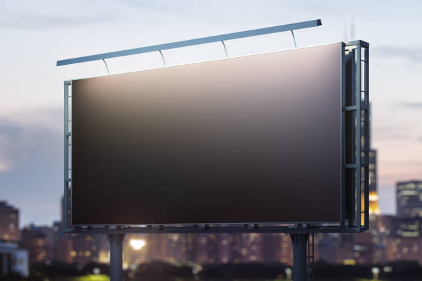 istock Blank black billboard on cityscape background at evening, perspective view. Mock up, advertising concept 2126840032