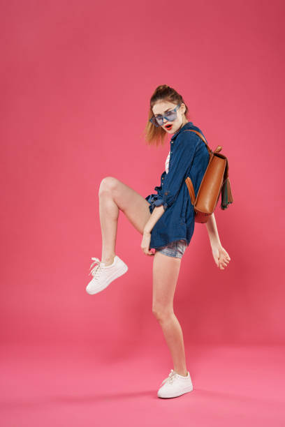 istock fashionable woman with backpack fun studio pink background 2126841093