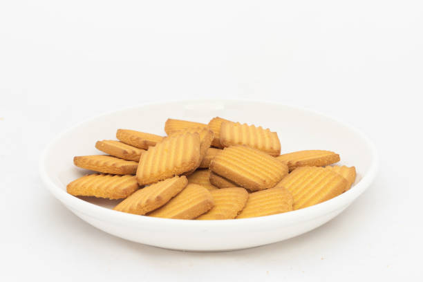 istock Crunchy tea biscuits in plate on white isolated background 2126842635