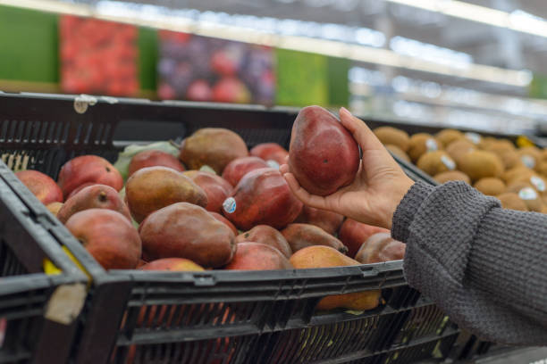 istock Hand holding a red pear in a supermarket. 2126858040