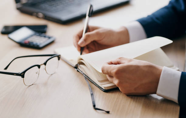 istock Male hands business finance documents glasses open laptop office and notepad 2126859620